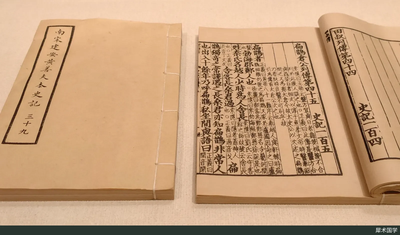 A Southern Song edition of the Shiji printed by Huang Shanfu of Jian’an, displayed in a showcase; the pages are printed in vertical columns, with small-character annotations interspersed in the main text